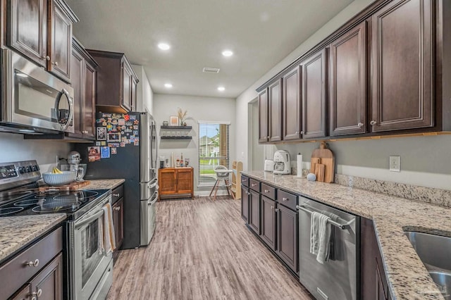 kitchen with appliances with stainless steel finishes, dark brown cabinetry, light wood-style flooring, light stone counters, and recessed lighting