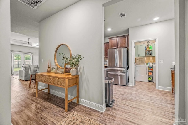 hall with light wood finished floors, washer and dryer, baseboards, and recessed lighting