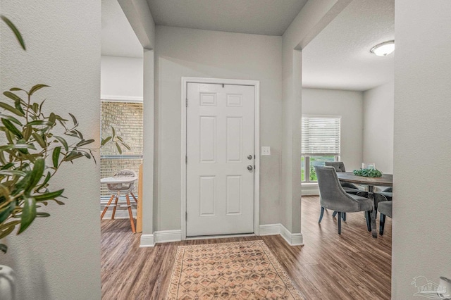 entrance foyer featuring wood finished floors and baseboards