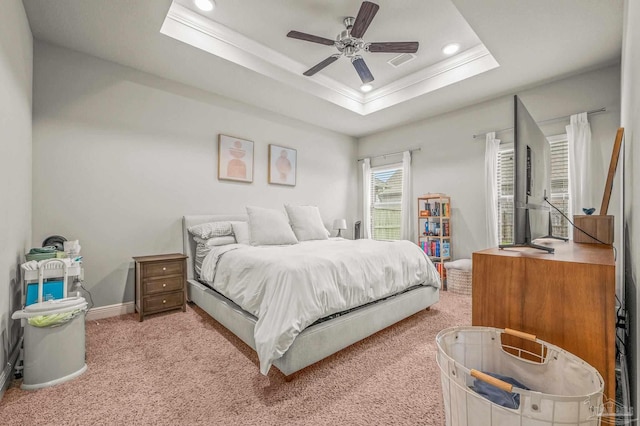 bedroom featuring crown molding, light colored carpet, a tray ceiling, recessed lighting, and baseboards