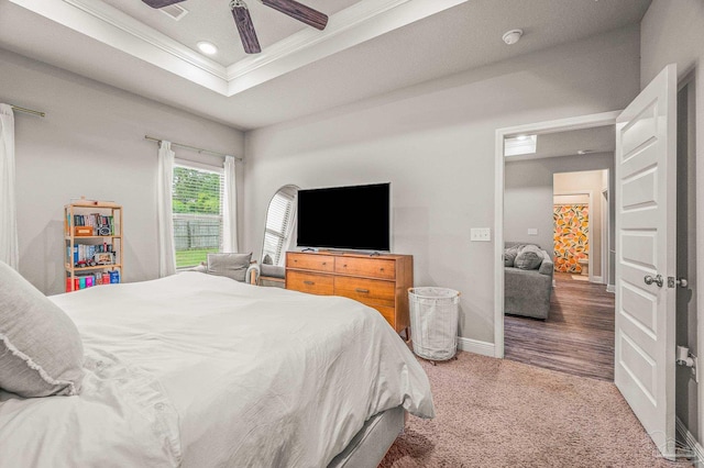 carpeted bedroom featuring ornamental molding, a raised ceiling, baseboards, ceiling fan, and recessed lighting