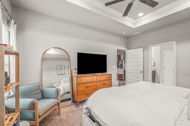 bedroom with crown molding, light colored carpet, recessed lighting, a raised ceiling, and connected bathroom