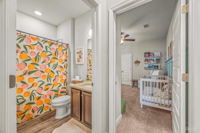 full bathroom featuring a ceiling fan, vanity, toilet, and curtained shower
