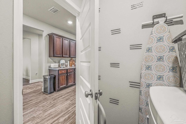 hall featuring light wood-style floors and baseboards