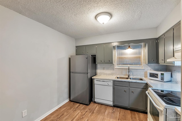 6205 E Forest Pines Dr, Pensacola, FL 32526 - kitchen with white appliances, gray cabinets, light wood-style floors, backsplash, and a textured ceiling