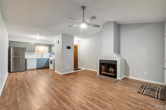 6205 E Forest Pines Dr, Pensacola, FL 32526 - unfurnished living room featuring a ceiling fan, light wood-style floors, vaulted ceiling, and a fireplace