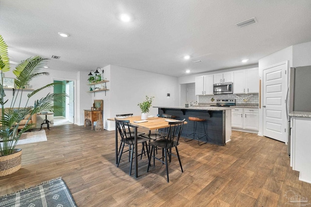 dining space featuring dark hardwood / wood-style floors and a textured ceiling