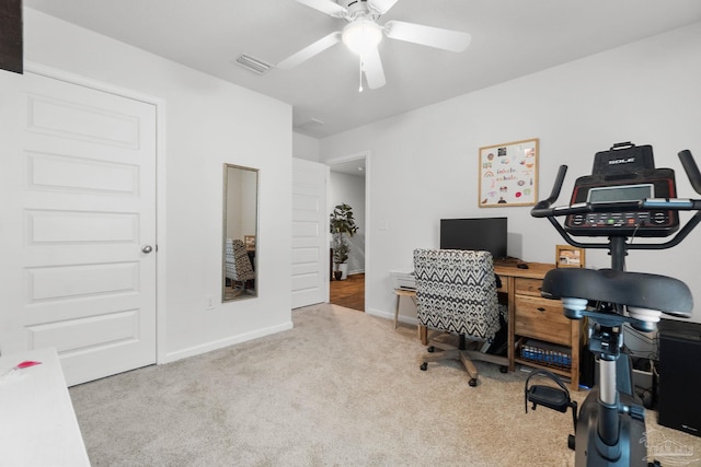 carpeted office space featuring ceiling fan