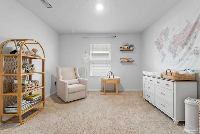 living area featuring light carpet and a textured ceiling