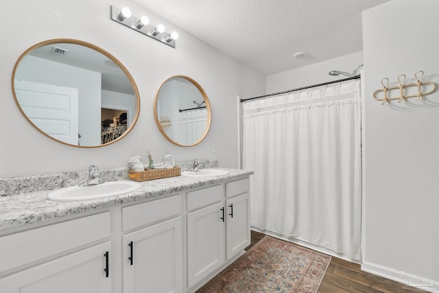 bathroom featuring vanity, a textured ceiling, and hardwood / wood-style flooring