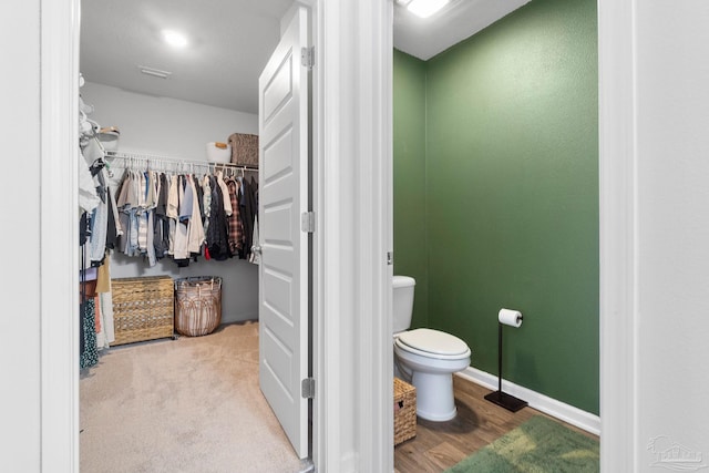 bathroom with toilet and wood-type flooring