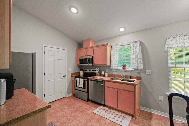 kitchen featuring sink, appliances with stainless steel finishes, and vaulted ceiling