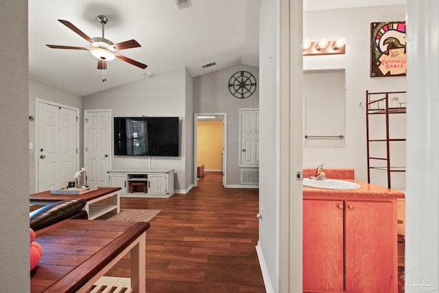 living room featuring ceiling fan, sink, dark wood-type flooring, and vaulted ceiling