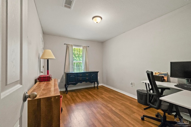 home office featuring a textured ceiling and wood-type flooring