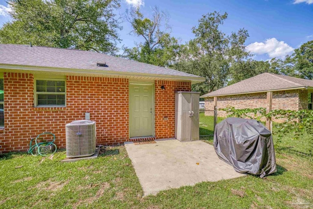 rear view of property with a patio, central AC, and a lawn