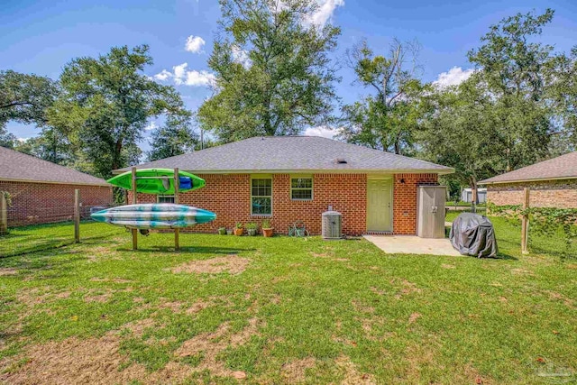 back of house featuring a patio area and a lawn