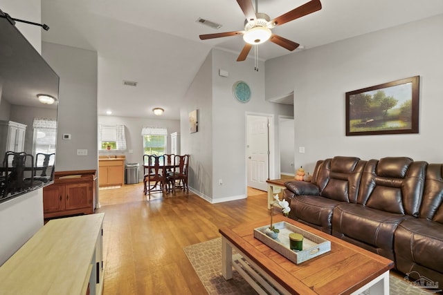 living room with high vaulted ceiling, light wood-type flooring, and ceiling fan