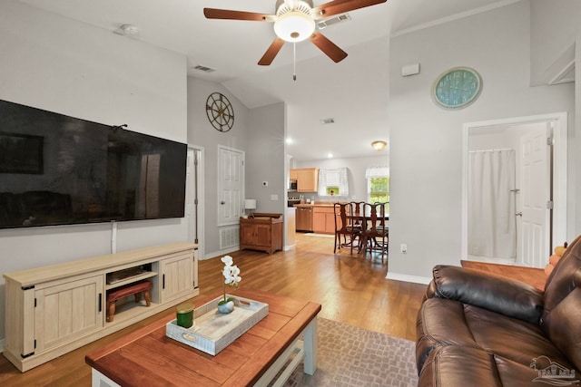 living room featuring high vaulted ceiling, light wood-type flooring, and ceiling fan