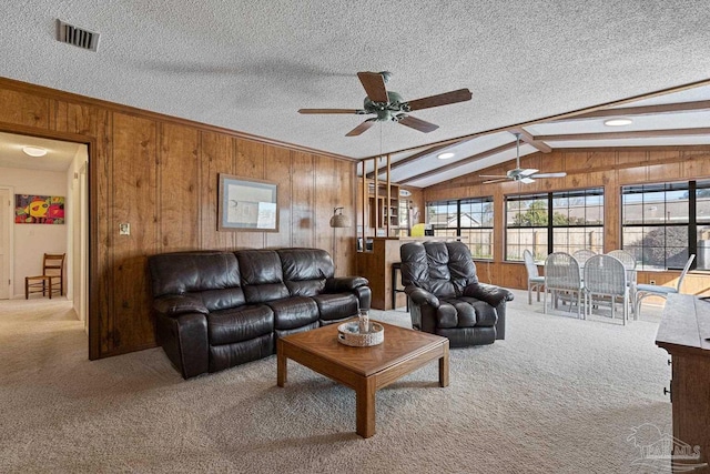 living room featuring vaulted ceiling with beams, a textured ceiling, and wood walls