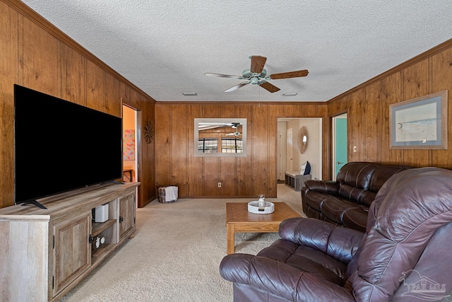 carpeted living room with ceiling fan, ornamental molding, and a textured ceiling