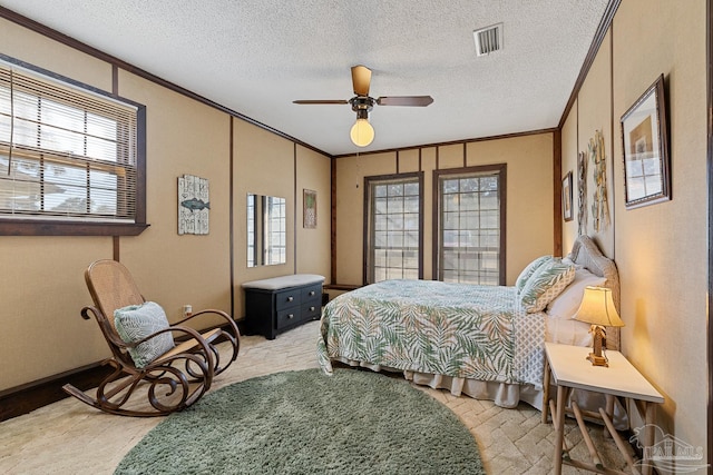 bedroom with crown molding, a textured ceiling, and ceiling fan