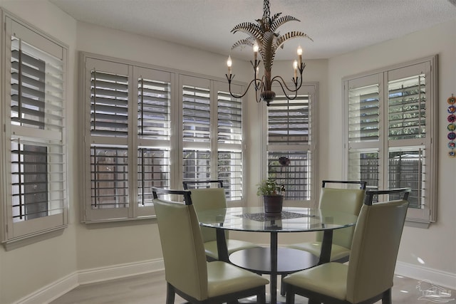 dining space with a textured ceiling and a notable chandelier