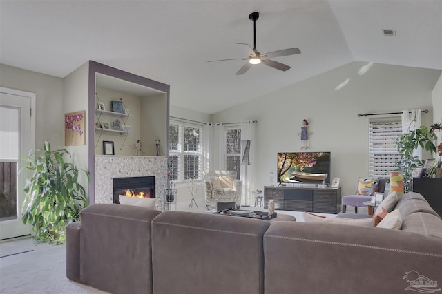 living room featuring carpet, ceiling fan, lofted ceiling, and a tiled fireplace