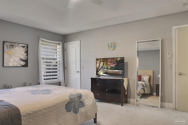 bedroom featuring ceiling fan, light carpet, and a closet