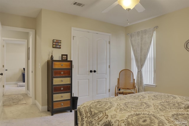 bedroom featuring ceiling fan, a closet, and light carpet