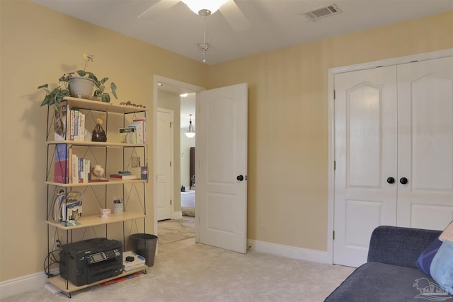 living area featuring carpet flooring and ceiling fan