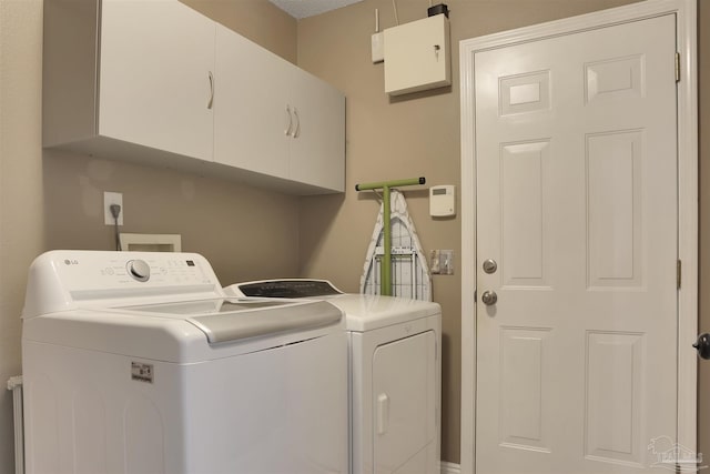 laundry area with cabinets and washing machine and clothes dryer