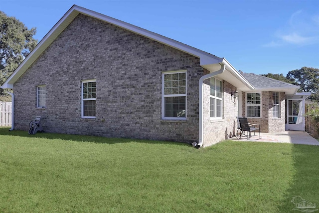 rear view of property featuring a patio and a lawn