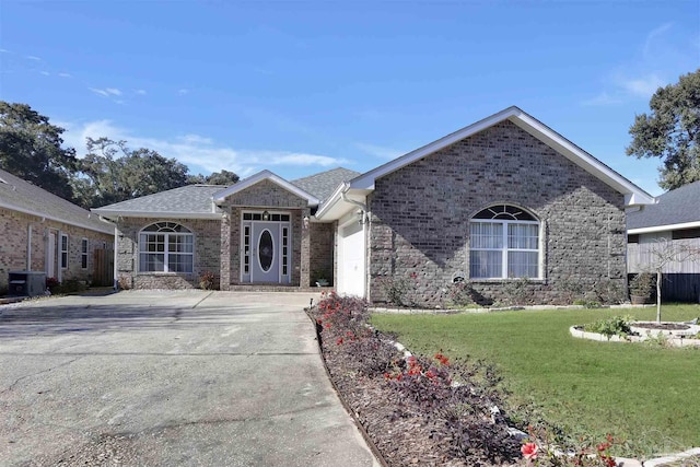 view of front of house featuring cooling unit, a garage, and a front lawn