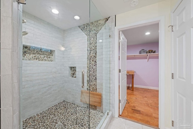 bathroom with an enclosed shower and tile patterned floors