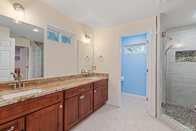 bathroom with tile patterned flooring, a shower with shower door, and vanity