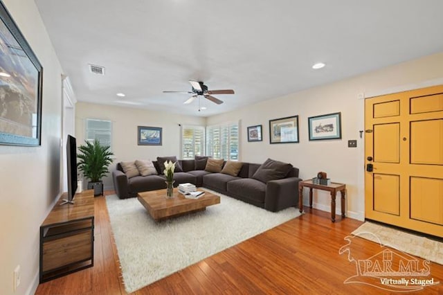 living room featuring ceiling fan and hardwood / wood-style floors