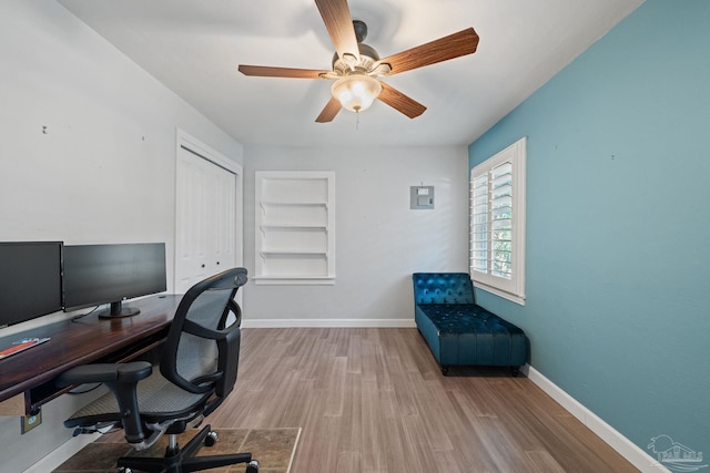 office area with built in features, hardwood / wood-style flooring, and ceiling fan