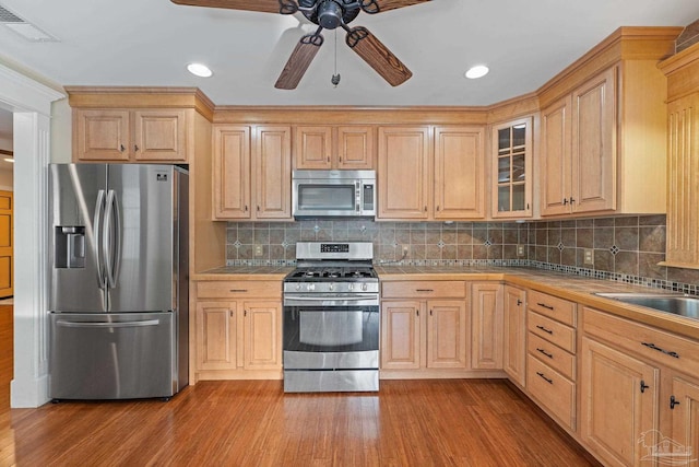 kitchen featuring light wood-type flooring, light brown cabinetry, and appliances with stainless steel finishes