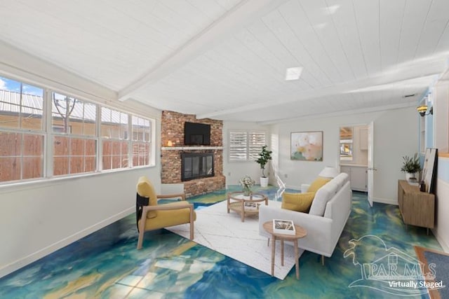 living room featuring beamed ceiling and a large fireplace