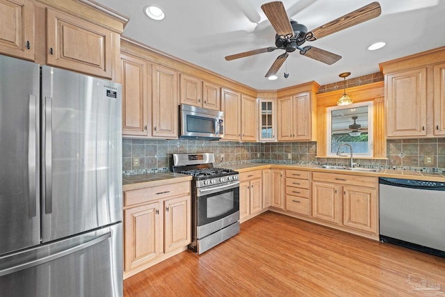 kitchen featuring light hardwood / wood-style floors, sink, pendant lighting, stainless steel appliances, and light brown cabinets