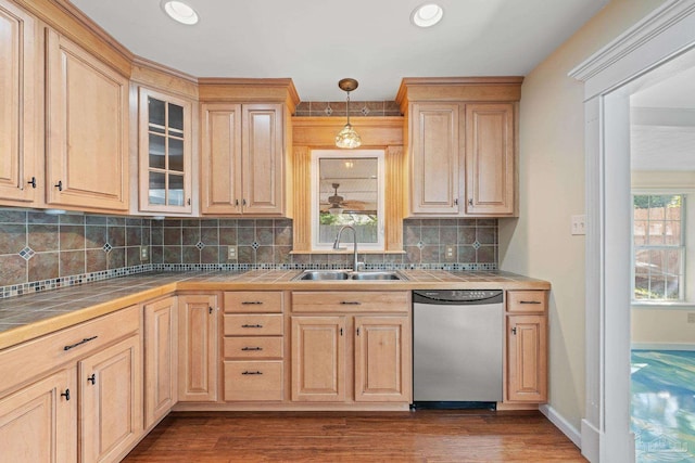 kitchen featuring pendant lighting, dishwasher, light brown cabinets, sink, and tile countertops