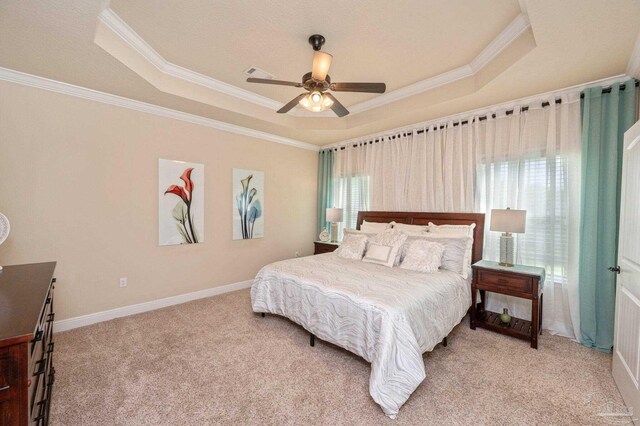 bedroom featuring a raised ceiling, ornamental molding, and light colored carpet