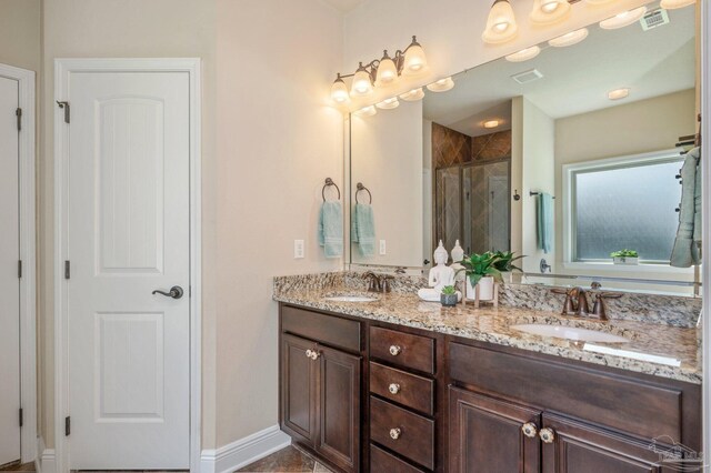 bathroom with double vanity, visible vents, a shower stall, and a sink