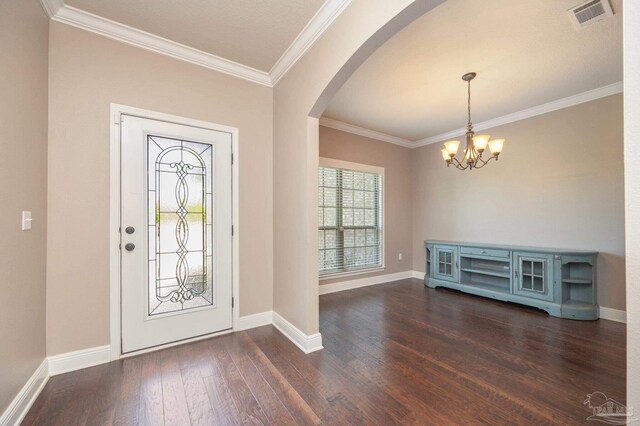 foyer entrance with visible vents, crown molding, arched walkways, dark wood-style floors, and a notable chandelier