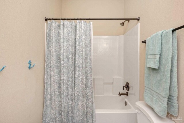 full bathroom featuring toilet and shower / tub combo with curtain