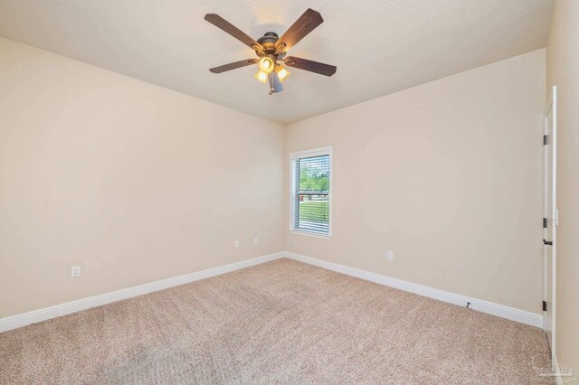 spare room with light colored carpet and baseboards