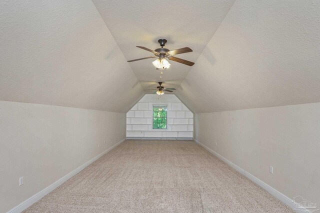 bonus room with a textured ceiling, vaulted ceiling, and baseboards