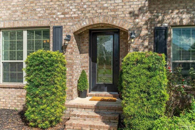 view of exterior entry with brick siding