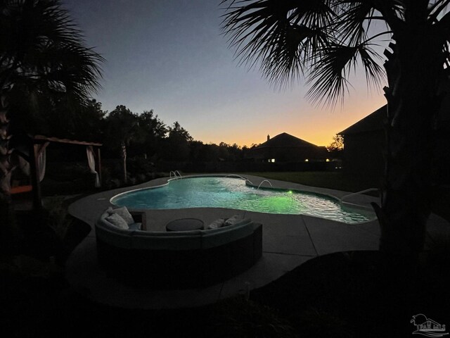 pool at dusk featuring an outdoor pool