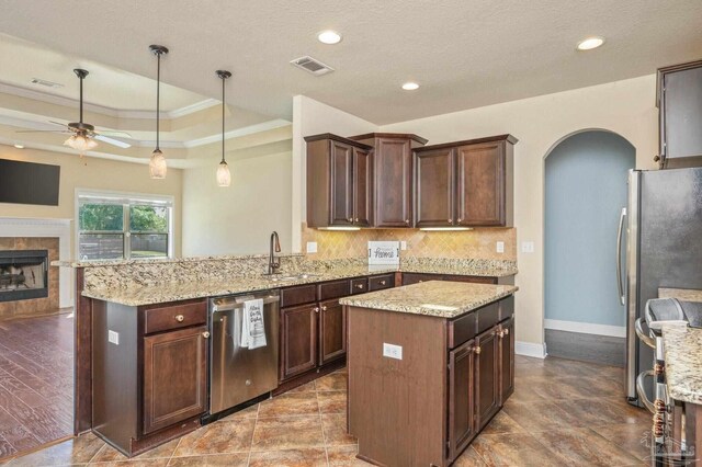 kitchen featuring visible vents, arched walkways, a sink, ornamental molding, and stainless steel appliances